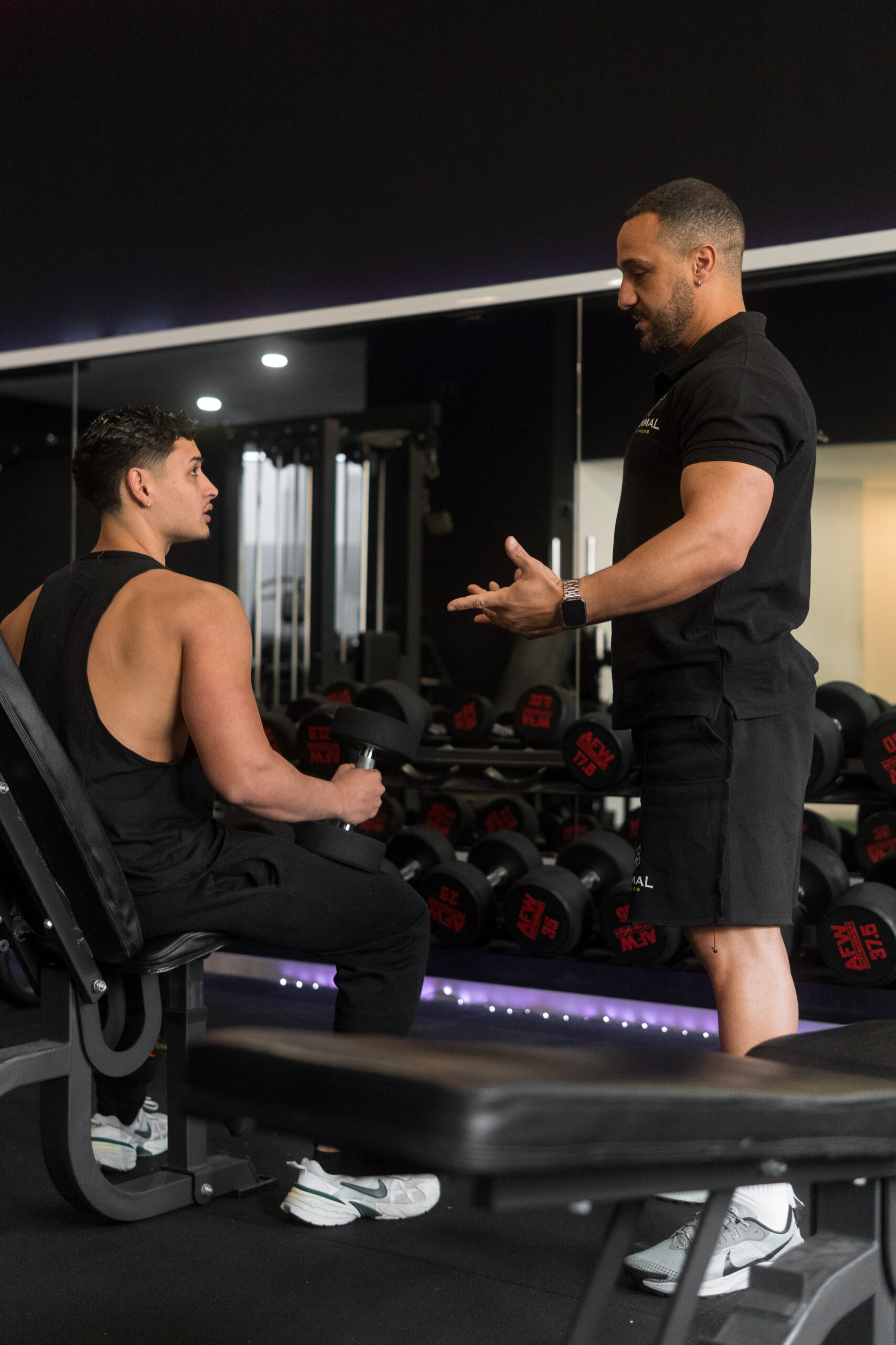 Entrenador personal guiando rutina de pesas en gimnasio de Sant Celoni